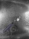 Close-up of water drops on the sink with a metal spoon. Royalty Free Stock Photo