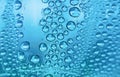 Close up water drops on sky blue tone background. Abstract sky blue wet texture with water drops on glass surface. Selective focus Royalty Free Stock Photo