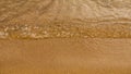 Close-up of a water edge and yellow sand summer beach background with copy space Royalty Free Stock Photo