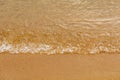 Close-up of a water edge and yellow sand summer beach background with copy space. Royalty Free Stock Photo