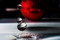 Close-up of water falling drops and splash crown from red Christmas toys. Royalty Free Stock Photo