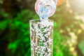 Close up of water flowing from drinking water bottle into glass on blurred green nature background Royalty Free Stock Photo