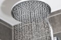 Close-up of water flows in small jets from metal rain shower in bathroom