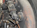 Close up of the water gauge controls and pipes of an old abandoned rusting steam locomotive