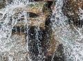 Close-up of water spashing down rocks in waterfall - droplets and rivlets everywhere - selective focus