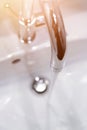 Saving water: Close up of spigot with clear, flowing water. Morning sun Royalty Free Stock Photo