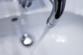 Saving water: Close up of spigot with clear, flowing water Royalty Free Stock Photo