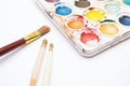 close-up of watercolors palette and brush bristles on white background Royalty Free Stock Photo