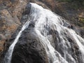 Close-up of the waterfall movement in the Park. The stream of water flows around the rock and falls down