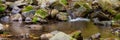 Close-up of the waterfall movement. The stream of water flows around the rock and falls down. Long exposure shot