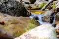 Close-up of the waterfall movement. The stream of water flows around the rock and falls down. Long exposure shot Royalty Free Stock Photo