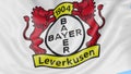 Close-up of waving flag with Bayer Leverkusen football club logo, seamless loop, blue background. Editorial animation