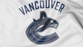 Close-up of waving flag with Vancouver Canucks NHL hockey team logo, 3D rendering Royalty Free Stock Photo