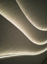 Close-up wavy curve pattern textured panel wall, glowing with led lights Royalty Free Stock Photo