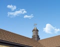 Close up of a weather vane on a roof,wind indicator, over blue sky