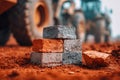 A close-up of weathered bricks stacked on reddish soil at a construction site with heavy machinery blurred in the background Royalty Free Stock Photo