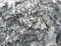 Close-up of Weathered Coastal Rock with Sand and Lichen Royalty Free Stock Photo