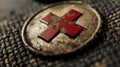 Close-up of a weathered coin with a red puzzle piece emblem, resting on textured fabric Royalty Free Stock Photo