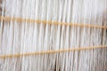 Close-up weaving cotton on manual loom. Selective focus of cotton thread on weaver machine. Thai cotton handmade. Homespun fabric