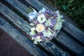 Close-up of wedding bouquet of fresh flowers lying on a blue wooden bench. Delicate bride bouquet on wooden background
