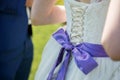 Close up of a wedding dress with a large purple silk bow Royalty Free Stock Photo