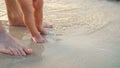 close-up, on wet sand, there are male and children& x27;s feet. a wave comes in. Vacation on ocean beach, Summer holiday Royalty Free Stock Photo