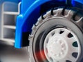 Close-up of a wheel from a blue children`s toy car. Closeup of children`s toys and goods