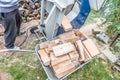 Close up of a wheelbarrow fully loaded with logs working and sawing wood, Germany