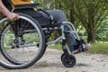 Close-up of a wheelchair in profile, a young woman sitting on it, in the middle of nature Royalty Free Stock Photo