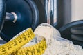 Close-up of Whey Protein Spoon Powder, with weights and tape measure