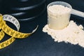 Close-up of Whey Protein Spoon Powder, with weights and tape measure