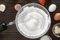 Close-up of a whisk and whipped egg whites to stiff peaks, a step in the preparation of breakfast dough or tender pancakes. White Royalty Free Stock Photo