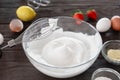 Close-up of a whisk and whipped egg whites to stiff peaks, a step in the preparation of breakfast dough or tender pancakes. White Royalty Free Stock Photo