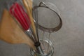 Whisker, wooden spoon, strainer and spatula on glass jar