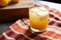 close up of a whiskey sour cocktail with a patterned napkin underneath