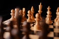 Close up of white and black chess pieces on board. Selective focus on first move of white pawn on chessboard. Concept of