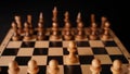 Close up of white and black chess pieces on board. Selective focus on first move of white pawn on chessboard. Concept of