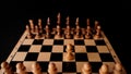 Close up of white and black chess pieces on board. Selective focus on first move of white pawn on chessboard. Concept of