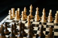Close up of white and black chess pieces on board. Selective focus on first move of white pawn on chessboard. Concept of Royalty Free Stock Photo