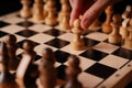 Close up of white and black chess pieces on board. Selective focus on first move of white pawn on chessboard. Concept of