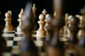 Close up of white and black chess pieces on board. Selective focus on first move of white pawn on chessboard. Concept of