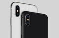 Close-up white and black rotated smartphone similar to iPhone X back sides with camera modules cropped