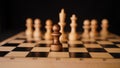 Close up of white and black wooden chess pieces on board. Selective focus on confrontation of black pawn opposite white