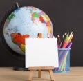 Close up of white blank easel for writing text, world globe