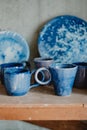 Close-up white and blue ceramic cups and dishes on shelves of pottery store Royalty Free Stock Photo