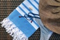 Close-up of a white and blue Turkish peshtemal / towel, bikini, white seashells and straw hat on a rattan lounger. Royalty Free Stock Photo