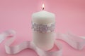 Close up of white candle lit isolated on pink background