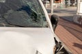 Close-up of a white car with significant front damage and shattered windshield, highlighting the aftermath of a road Royalty Free Stock Photo