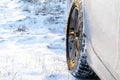 Close-up of white car wheel on winter road, countryside landscape, covered in snow - Kiev region, Ukraine, January 15 2020