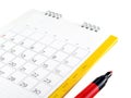 white cardboard desk calendar with days and date in grid and red marker pen isolated on white background Royalty Free Stock Photo